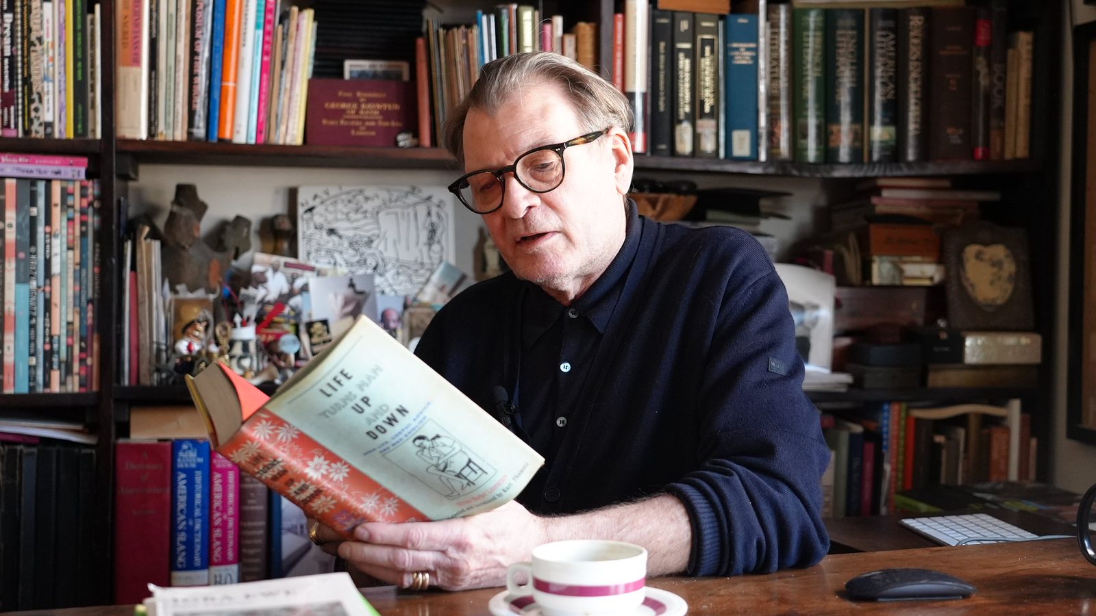 Kurt Thometz reading from the anthology Life Turns Man Up and Down at his desk