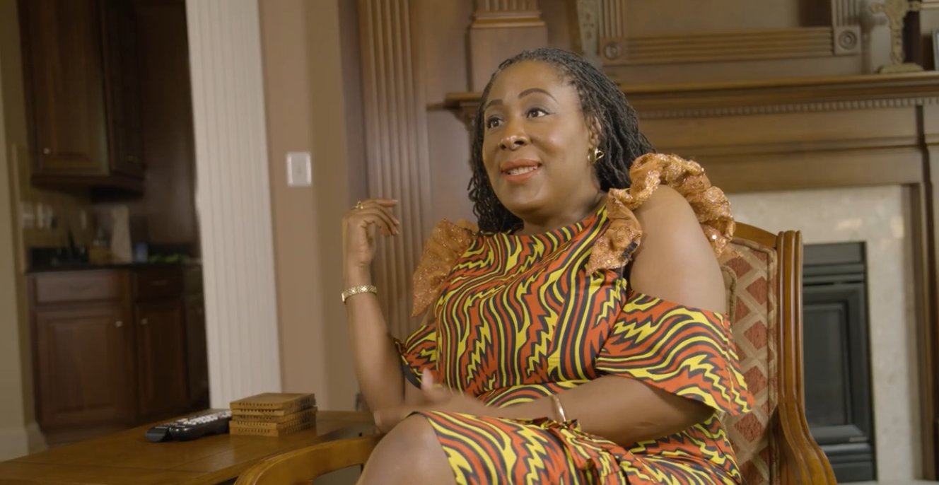 Uju Anya seated in an armchair, mid-sentence, during her filmed interview